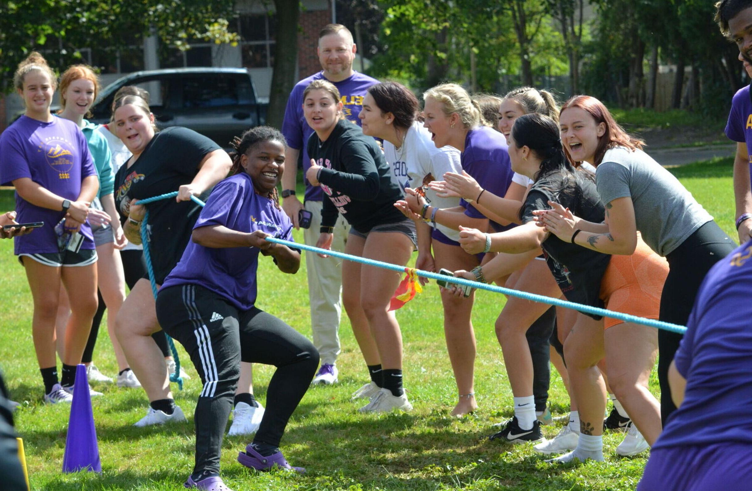 Students cheer on a team of two competing in tug-of-war